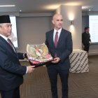 Agung Kurniadi, embajador de Indonesia, entrega el escudo de armas y la bandera de su país, al cónsul honorario, Juan Carlos Díaz-Granados.