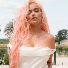 La artista lució un vestido blanco combinado con una mini cartera roja de Jacquemus que cuestan más de 1,300 dólares.