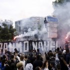 Un manifestante vestido de negro se ve en lo alto de una señal de tráfico, mientras la gente participa en una marcha en memoria de Nahel, de 17 años, asesinado por la policía francesa en Nanterre, cerca de París, Francia, 29 de junio de 2023.
