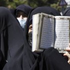Una mujer iraní sostiene un ejemplar del libro sagrado del Corán mientras se manifiestan frente a la embajada de Suecia en Teherán, Irán, el 30 de junio de 2023.