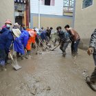 Moradores de la aldea de limpian los escombros de un deslizamiento de tierra en una zona de Zhangzigou.