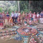 Un grupo de personas aparecen rodeando una instalación tradicional en la nacionalidad Tsa"chila.