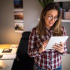 Panorama. Una persona recurre a una red wifi doméstica en una tablet y tiene abierto Internet en su PC.