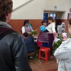 Cuenca. Un grupo de turistas experimenta con una sesión de cura en el tradicional mercado 10 de Agosto.