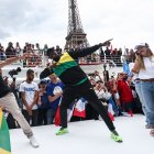 El velocista retirado jamaiquino Usain Bolt (c) compartió con dirigentes del comité organizador y deportistas en el acto del inicio del conteo regresivo frente a la Torre Eiffel.