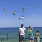 Una mujer fotografía aves en una playa de Odesa. El bloqueo ruso de los puertos de Odesa recientemente reanudado acentúa el profundo estrangulamiento de la economía de la región, mientras la ciudad sufre por segundo año consecutivo un golpe a su estatus de destino turístico.