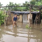 En la imagen un registro de archivo de una mujer frente a su casa inundada en el municipio de Monjaras (sur de Honduras).