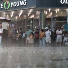 Turistas extranjeros se ven atrapados en una lluvia repentina en la calle Myeongdong en Seúl, Corea del Sur, el 31 de julio de 2023, en medio de una alerta de ola de calor.EFE/EPA/YONHAP SOUTH KOREA OUT