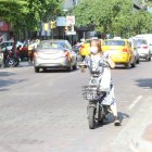 Una mujer maneja una moto en contravía en plena avenida 9 de Octubre, de Guayaquil.