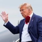 Donald Trump saluda a los presentes mientras se baja de su avión, en su camino a enfrentar un juez por acusaciones federales de conspirar para revertir las elecciones 2020.