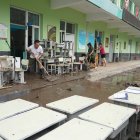 Profesores limpian el agua acumulada en el pueblo de Qizhongkou en la provincia de Hebei.