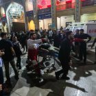 Un herido es evacuado -la noche del 13 de agosto- después de un ataque con armas de fuego contra el mausoleo chií Shah Cheragh.