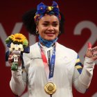 La pesista en lo alto del podio de Tokio 2020 con la dedicatoria a su mamá y hermano, fallecidos.