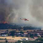 Un helicóptero contra incendios sobrevuela la zona afectada por un incendio forestal cerca del puerto de Alexandroupolis, Grecia, este domingo 20 de agosto.