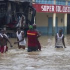 Personas caminan por calles inundadas de Santo Domingo debido al paso de la tormenta tropical Franklin.