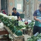 Voluntarios colocan cuidadosamente las flores donadas.