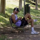 Un hombre descansa en la sombra de un parque en Madrid