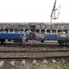 Bomberos indios terminan de extinguir el fuego de un vagón de tren.