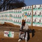 Una mujer posa junto a las imágenes de candidatos en el barrio de Mbare, en Harare, el 21 de agosto.
