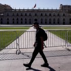 Un hombre camina usando mascarilla frente al Palacio de la Moneda, en Santiago.
