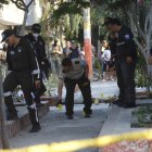 Varios policías en la escena del crimen, identifican los "indicios balísticos" que evidencian el número de disparos que propinaron a las víctimas.