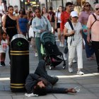 Un hombre sin hogar en la calle Oxford de Londres rodeado de transeúntes, hoy 5 de septiembre de 2023.