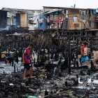Personas observan los restos y buscan objetos tras un incendio de grandes proporciones que destruyó más de 100 viviendas de madera construidas sobre palafitas, hoy en Santo (Brasil). Hasta el momento se desconoce si hay víctimas fatales y según las autoridades, al menos 15 personas afectadas por el humo fueron transferidas a centros hospitalarios de la región. Los hechos comenzaron hacia las 10:30 hora local del lunes (2:30 GMT) en el barrio Rádio Clube, en la zona norte de Santos, en el litoral del estado de Sao Paulo, en donde un equipo de 43 bomberos con la ayuda de 15 vehículos de la corporación lograron contener las llamas cuatro horas después. EFE/ Isaac Fontana