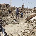 Varias personas caminan entre los escombros en la aldea de Tafagajt, en Marruecos, cerca del epicentro del devastador terremoto.