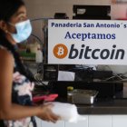 Negocio.- Una mujer compra alimentos en un establecimiento que aceptan pagos en bitcóin.