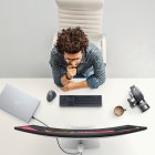 Panorama. Una persona aparece con su ordenador portátil conectado a monitor de alta gama.