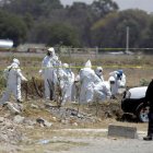 Fotografía de archivo de peritos forenses que realizan el levantamiento de cuerpos hallado