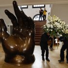 Empleados dejan un arreglo floral junto a la escultura La Mano de Fernando Botero, en el Museo Fernando Botero en Bogotá (Colombia).