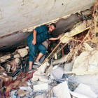 Varias personas buscan supervivientes entre los escombros de un edificio que se derrumbó durante las inundaciones tras el paso de la tormenta mediterránea Daniel por la ciudad oriental libia de Derna, el 14 de septiembre de 2023