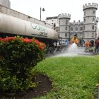 Tarea. Un trabajador riega agua en áreas verdes.
