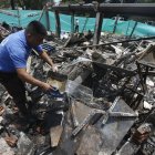 Un hombre vierte agua en los escombros de una vivienda destruida por un ataque con carro bomba en Timba.