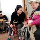 Labores. Blanca Guambaña enseña la forma de ir trenzando las hebras para darle forma al sombrero.