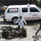 Técnicos antiexplosivos inspeccionan un carro bomba, activado contra una subestación de policía hoy, en el corregimiento Potrerito, del municipio de Jamundí, Valle del Cauca (Colombia).