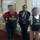 Fotografía cedida este jueves, 5 de octubre, por la Policía Nacional de Perú en la que se registró a una oficial (c) junto a dos detenidas y presuntas integrantes de una facción del grupo criminal transnacional venezolano "Tren de Aragua", en Lima (Perú).