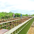 Prevención. Un par de obreros se ocupan en el proceso de la instalación de uno de los puentes bailey.