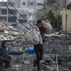 Una mujer palestina (L) sentada entre los escombros del barrio destruido de Al-Ramal tras un ataque aéreo israelí en la ciudad de Gaza, el 10 de octubre de 2023.