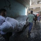 Un cuerpo es cargado del lugar del ataque aéreo de Israel en el campo de refugiados Shati en Gaza