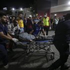 Vista de personas que llevan a un periodista palestino herido en Gaza, el 10 de octubre de 2023.