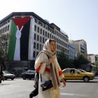 Teherán. Mujeres iraníes caminan junto a una enorme bandera palestina colgada en un edificio en esta capital.