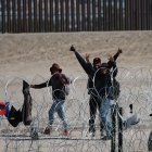 Espera. Un grupo de migrantes a un costado de la frontera.