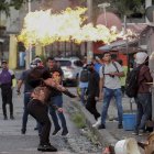 Manifestantes se enfrentan a la policía durante una protesta hoy, en las afueras de la Asamblea Nacional de Ciudad de Panamá (Panamá).