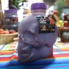 Novedades. Colada morada envasada en una calavera plástica, y pan de muerto junto a las guaguas.