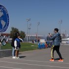Varias personas se toman fotos afuera del Estadio Nacional. Es la primera vez que Chile acoge una cita de este tipo, pero deja dudas.