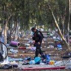 Un oficial israelí camina entre las pertencias de lo jovenes asistentes al Festival Super Nova en Re"im,