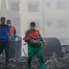 Gaza. Un palestino carga a una niña herida que ha sido recuperada de entre los escombros.