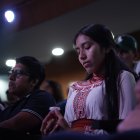 Una mujer indígena acude a una iglesia cristiana en Guayaquil junto a un alimento propio de la cultura